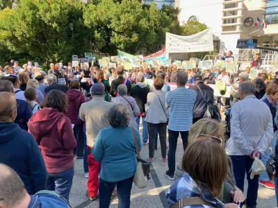 Septembre 2022 : une foule de personne de dos avec des pancartes lors d'une des manifestations devant l’hôtel de ville pour sauver l’île Héloïse de la bétonnisation